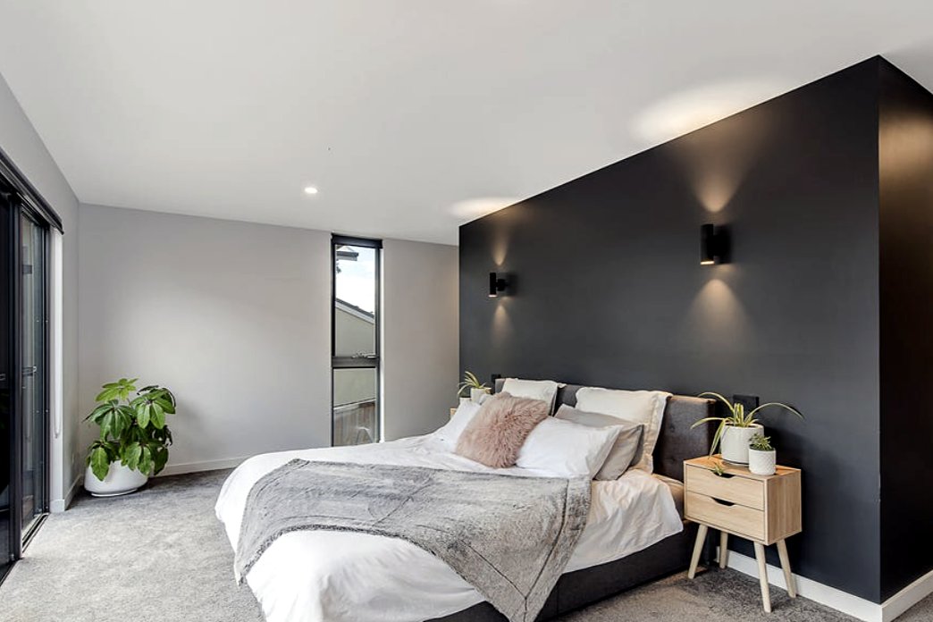 Fort Direction main bedroom with charcoal feature wall and wall lights