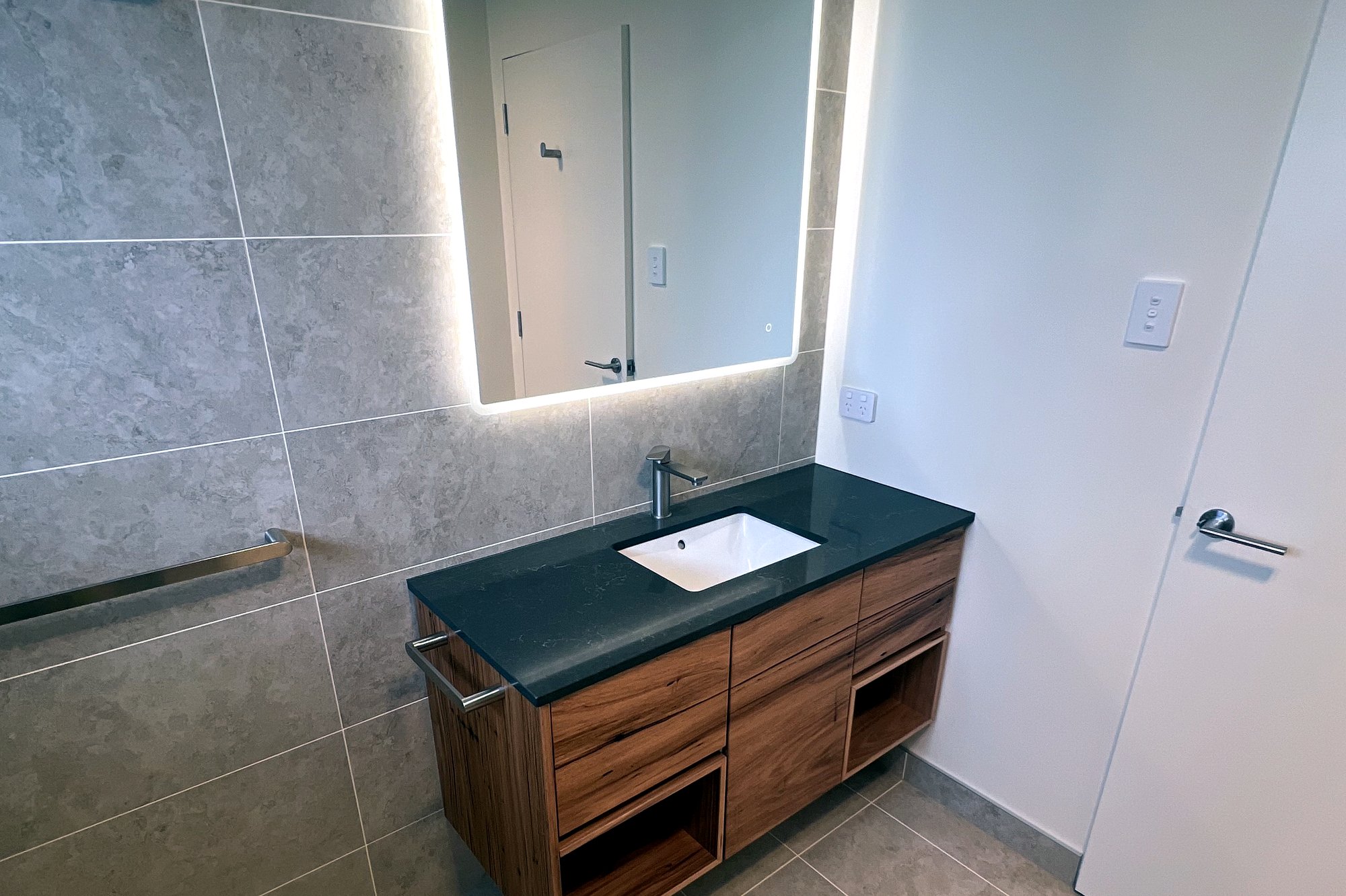 Richmond ensuite vanity with backlit mirror and dark stone top